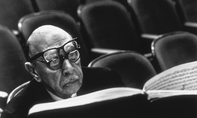 Igor Stravinsky wearing two pairs of glasses while reading musical score during a rehearsal