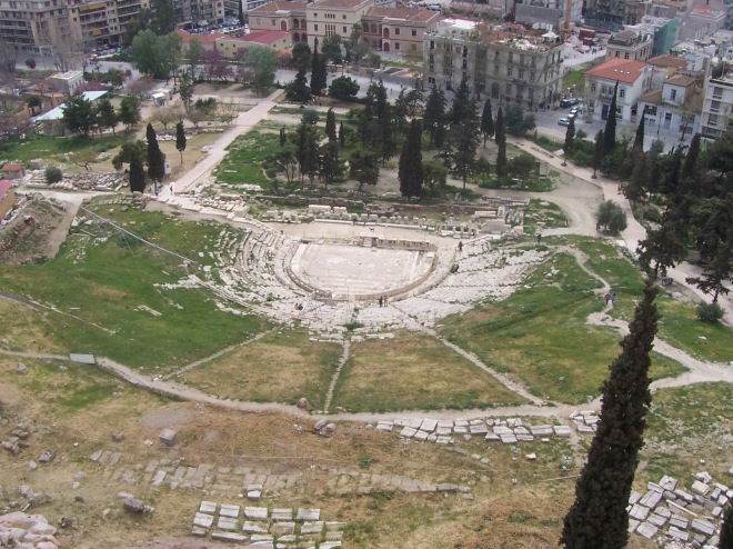 O Teatro de Dioniso, visto do alto da Acrópole, com parte da moderna Atenas ao fundo